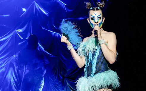 Performer in vibrant costume at Madame Arthur cabaret show, Paris.