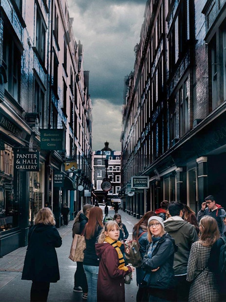 Visitors exploring Harry Potter film locations in a narrow London alley.