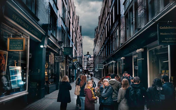 Visitors exploring Harry Potter film locations in a narrow London alley.