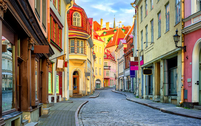 Cobbled street with colorful medieval buildings in Tallinn's Old Town, Estonia.