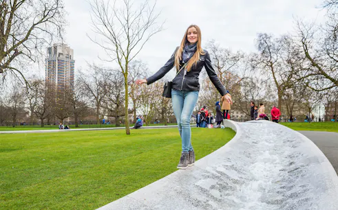 Woman walking along the Diana Memorial Fountain in Hyde Park, London.