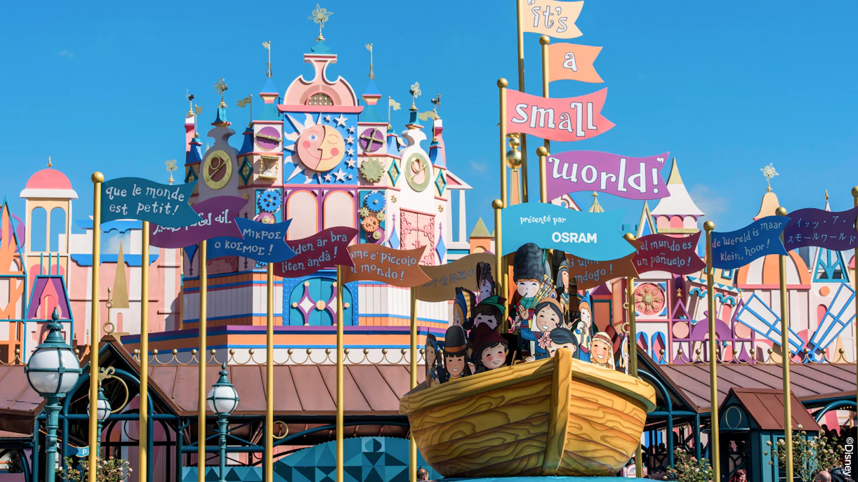 Disneyland Paris It's a Small World ride facade with colorful signs and characters.