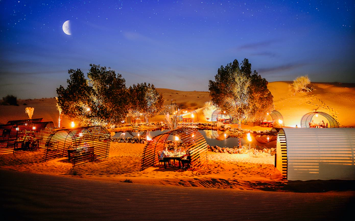Private cabanas under a starry sky in a desert oasis, Dubai.