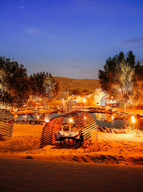 Private cabanas under a starry sky in a desert oasis, Dubai.