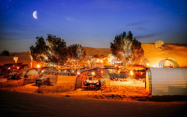Private cabanas under a starry sky in a desert oasis, Dubai.