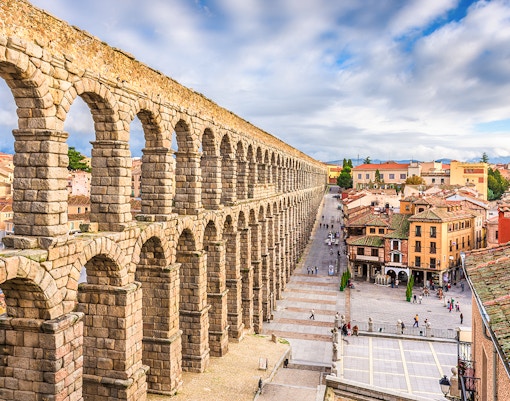 Ancient Roman aqueduct in Segovia, Spain, overlooking city streets and historic buildings.