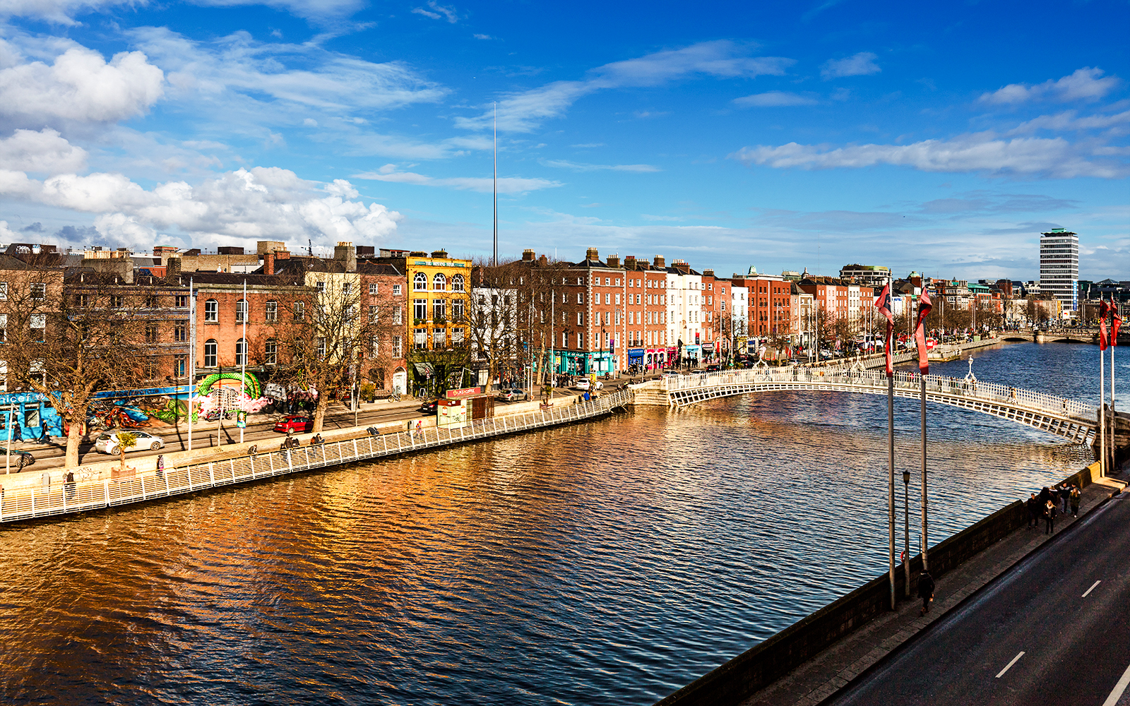 Ha'penny Bridge over River Liffey with colorful buildings, Dublin, Ireland.