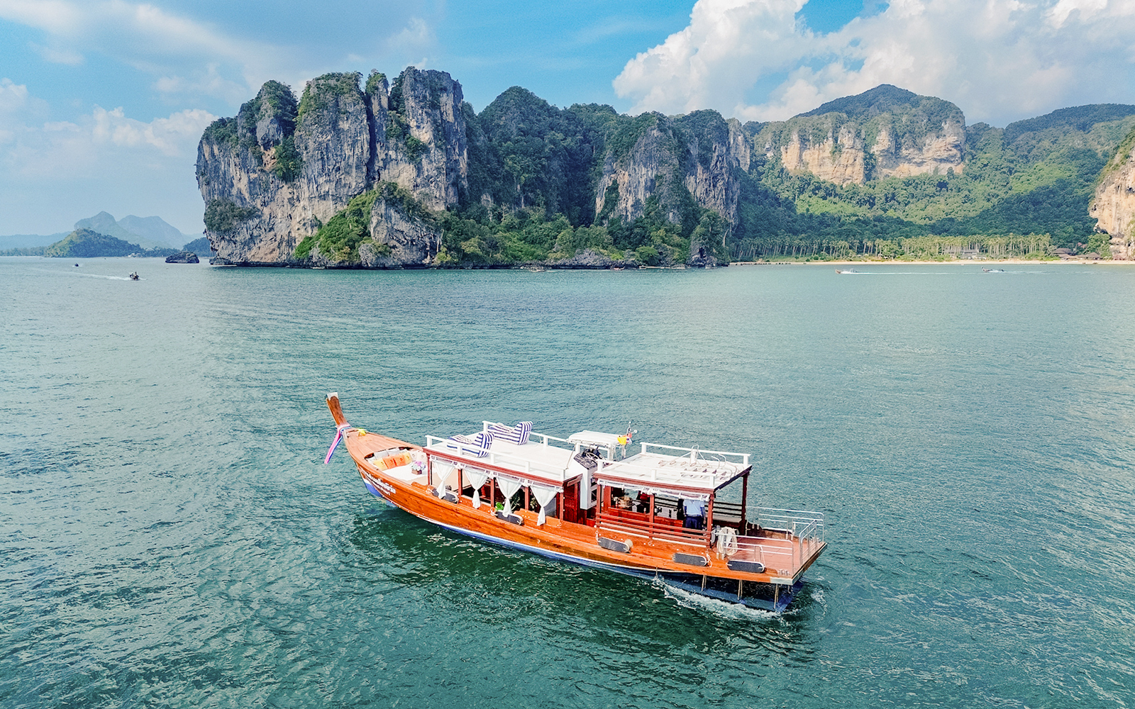 Long tail boat on the water near limestone cliffs, Ko Hong, Thailand.