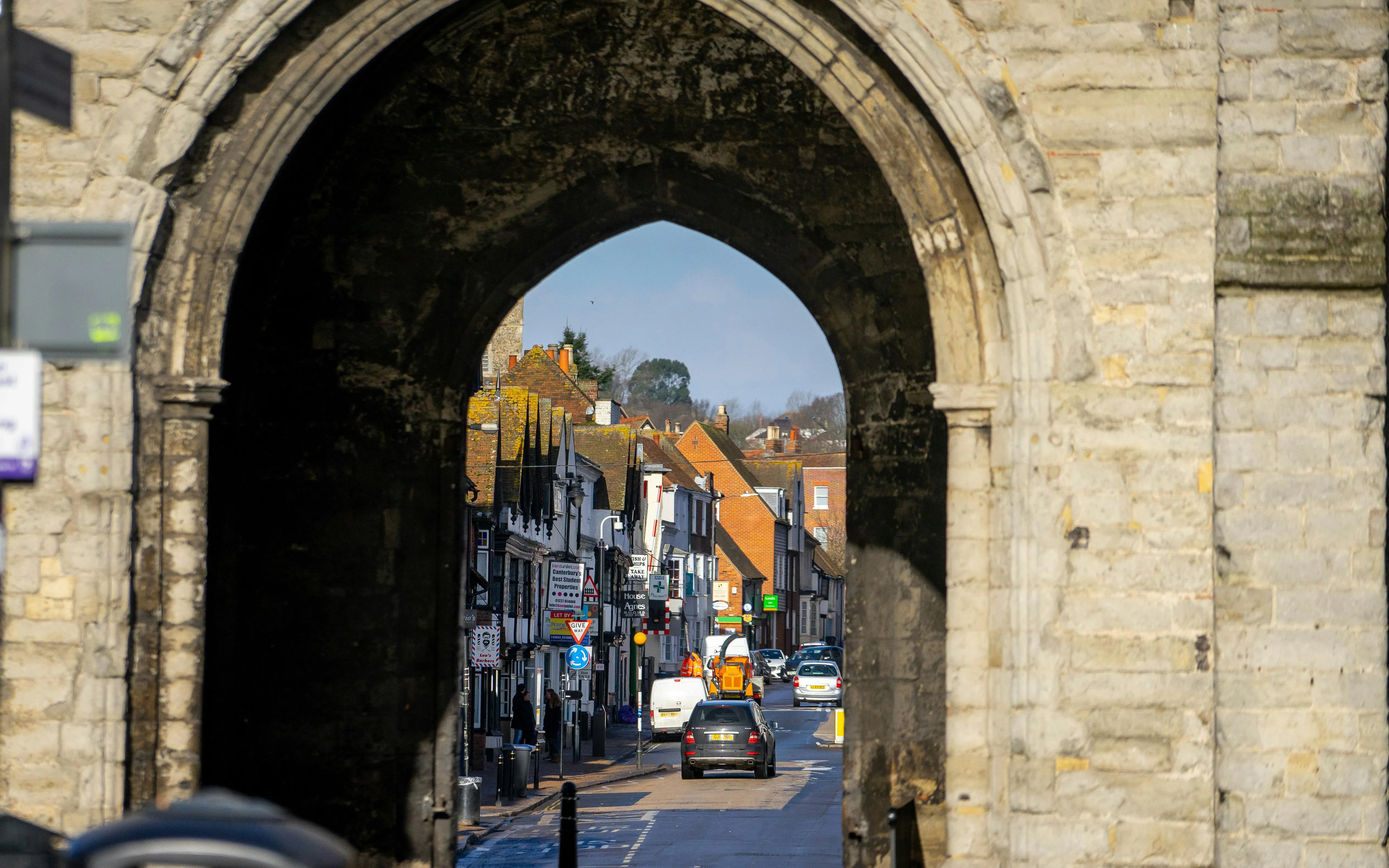 Westgate Towers archway framing a street view in Canterbury, United Kingdom during winter.
