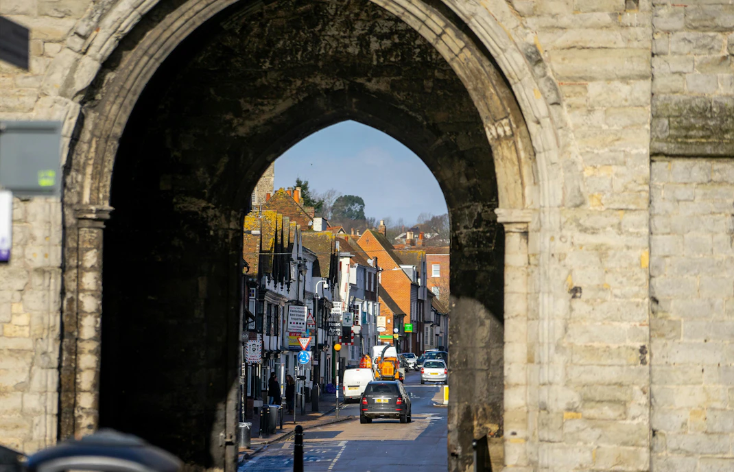 Westgate Towers archway framing a street view in Canterbury, United Kingdom during winter.