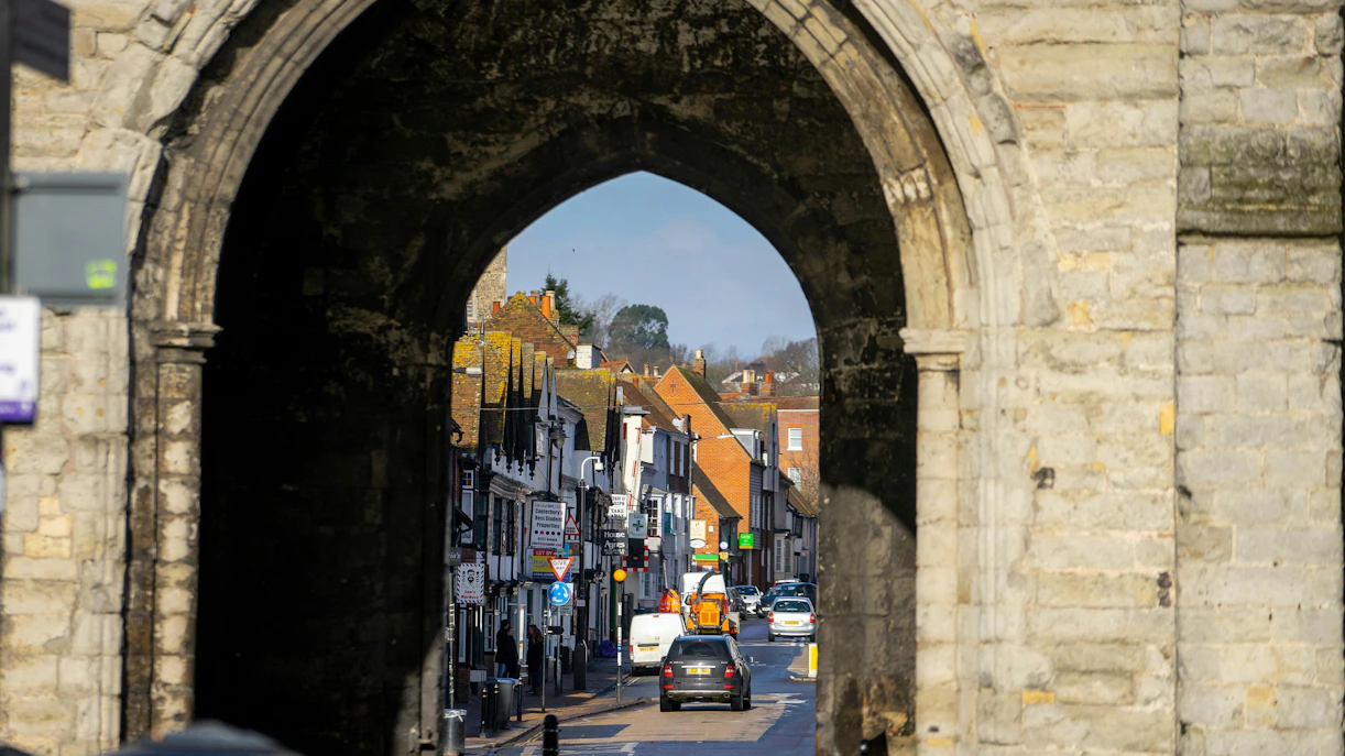 Westgate Towers archway framing a street view in Canterbury, United Kingdom during winter.