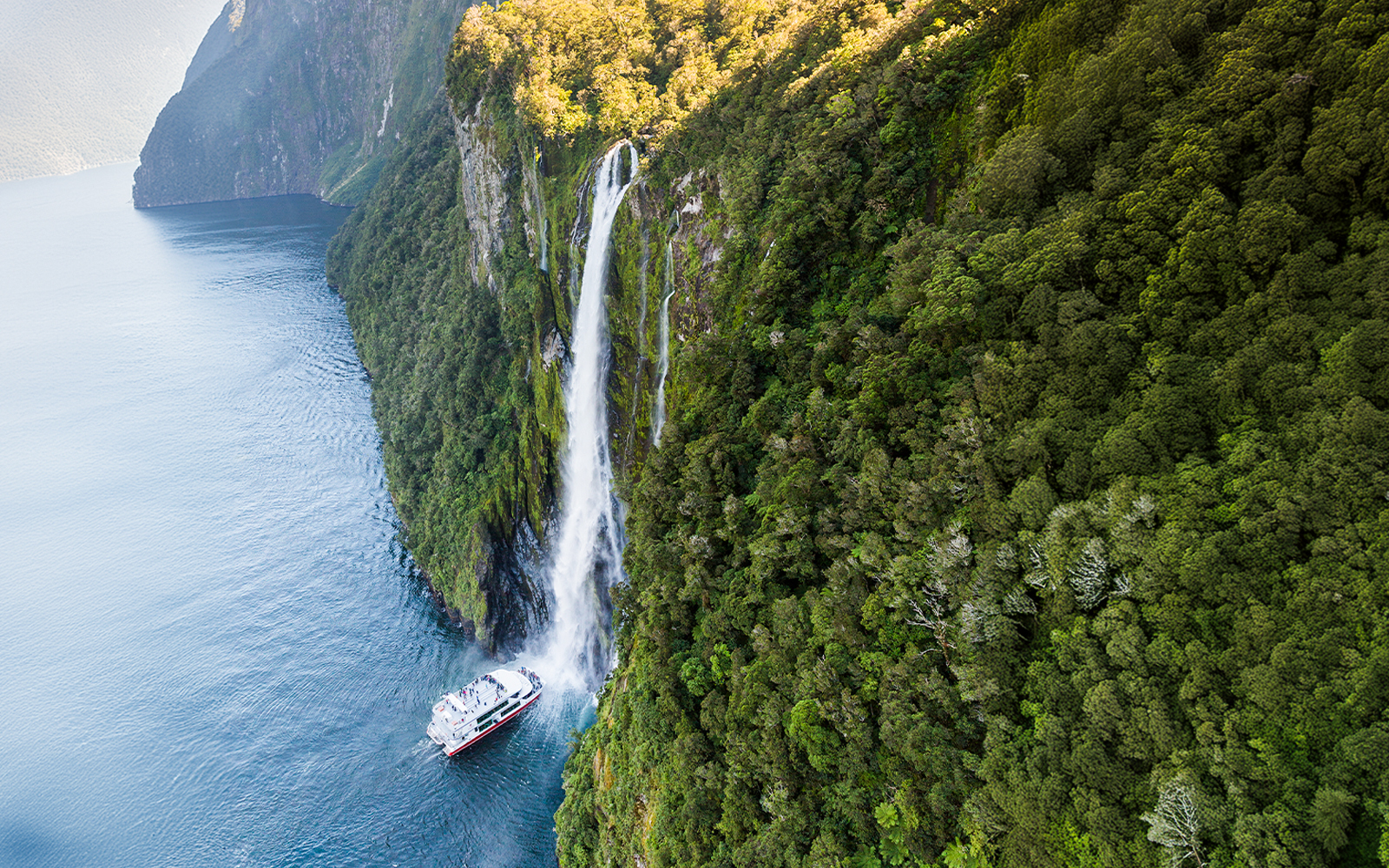 Cruise ship near Stirling Falls in Milford Sound, New Zealand.