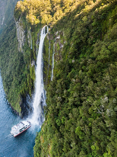 Cruise ship near Stirling Falls in Milford Sound, New Zealand.
