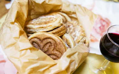 Traditional tigelle bread and red wine on a Bologna food tour.