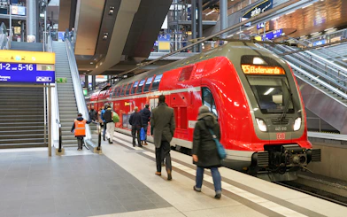 Local train at German railway station with passengers boarding, Interrail pass travel.