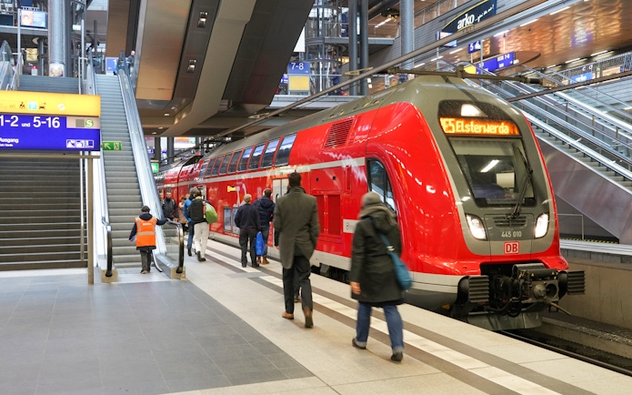 Local train at German railway station with passengers boarding, Interrail pass travel.