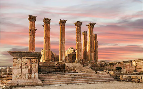 Roman columns at Jerash ruins during sunset, part of Jerash & Ajloun Castle Day Trip from Amman.