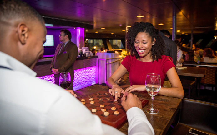 Woman enjoying a board game on a cruise ship lounge.