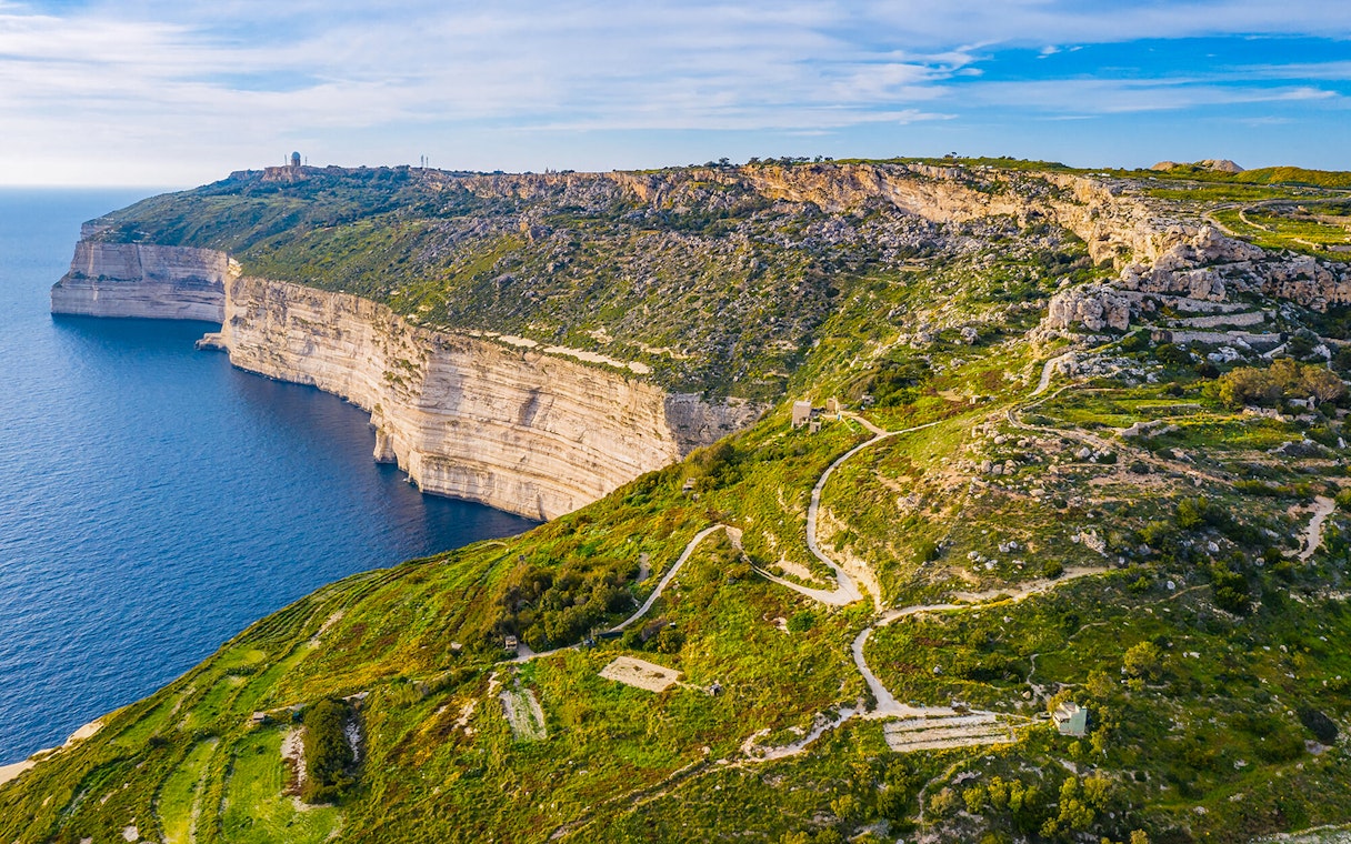 Dingli Cliffs overlooking the Mediterranean Sea, Malta, with winding paths and lush greenery.