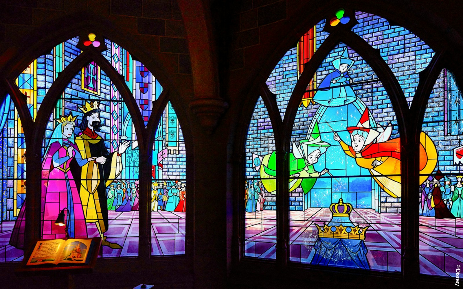 Sleeping Beauty Castle interior at Disneyland Paris with ornate stained glass windows and medieval decor.