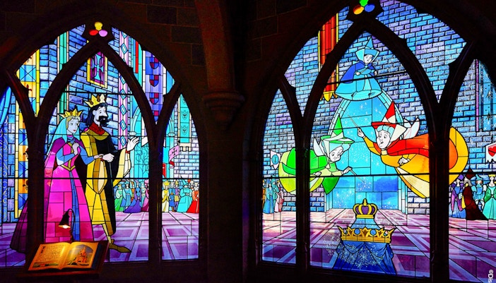 Sleeping Beauty Castle interior at Disneyland Paris with ornate stained glass windows and medieval decor.