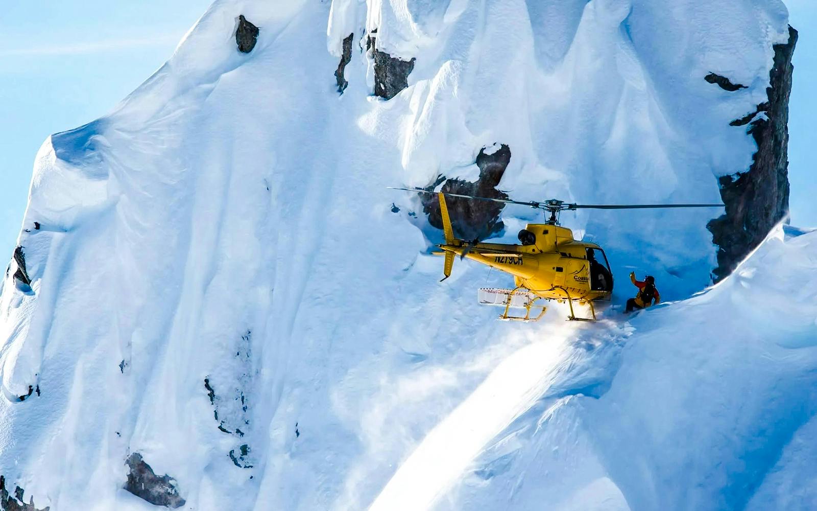 Helicopter landing on snowy glacier during Juneau tour with dog sledding.