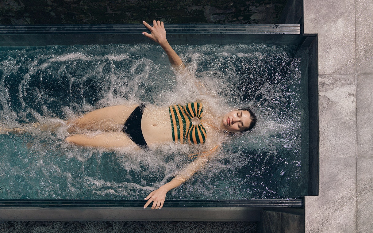 Person relaxing in a spa pool at QC Terme Milano, Italy.