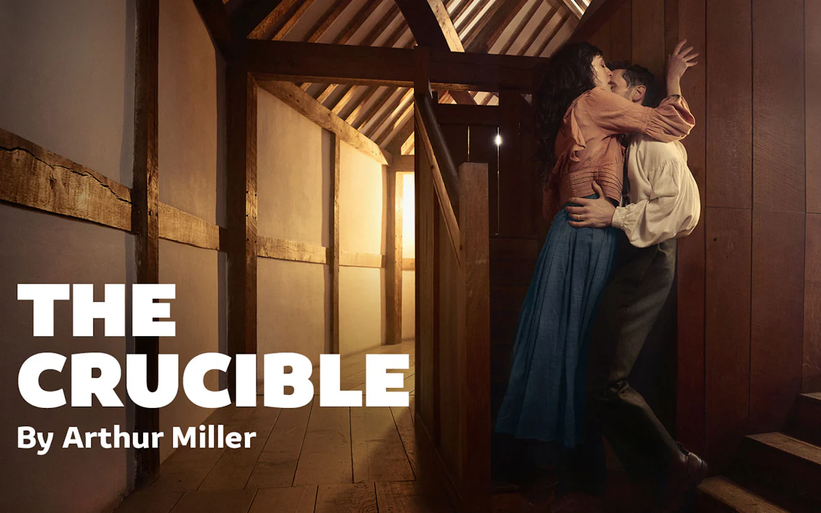 Couple embracing in a wooden interior, promoting Arthur Miller's play "The Crucible.
