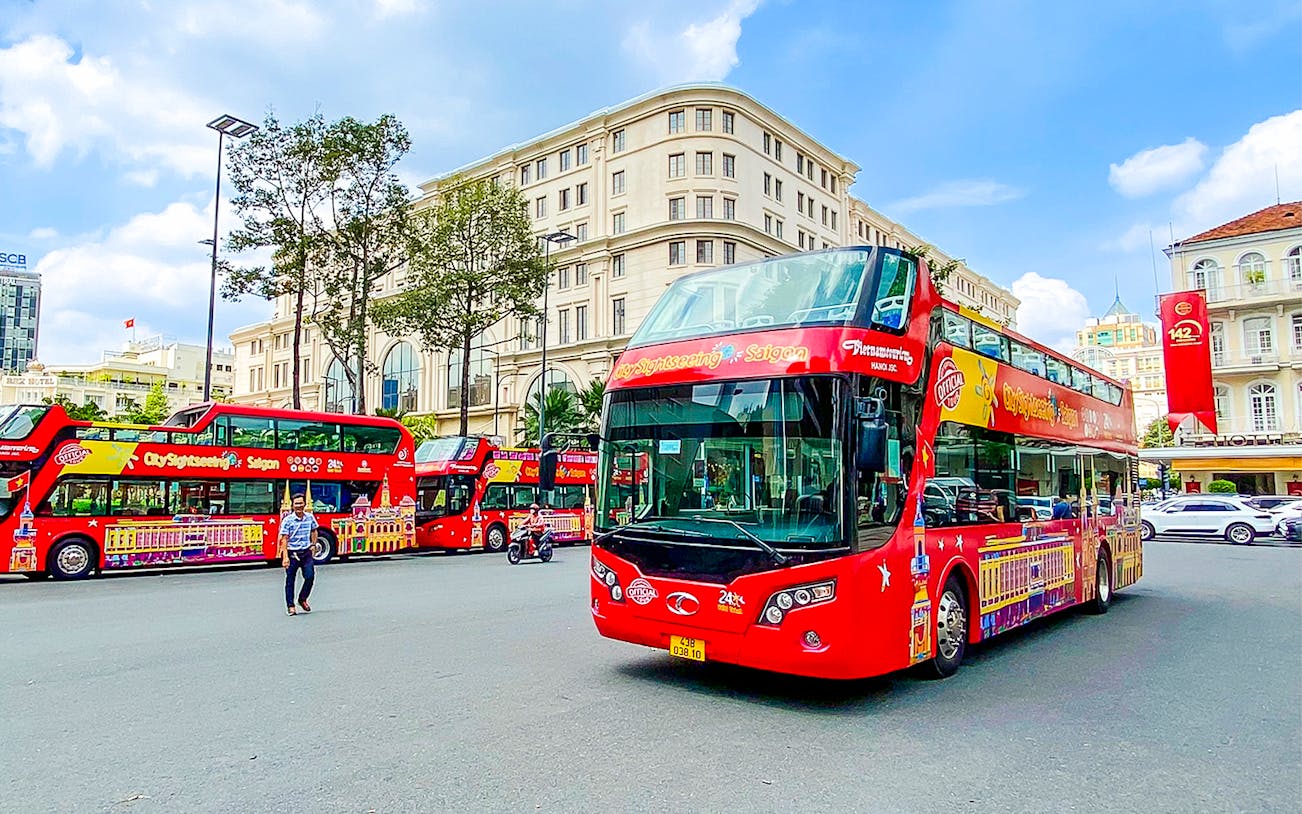Red double-decker bus on Saigon Hop-on Hop-Off Tour in Ho Chi Minh City street.
