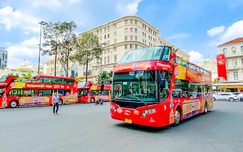 Red double-decker bus on Saigon Hop-on Hop-Off Tour in Ho Chi Minh City street.