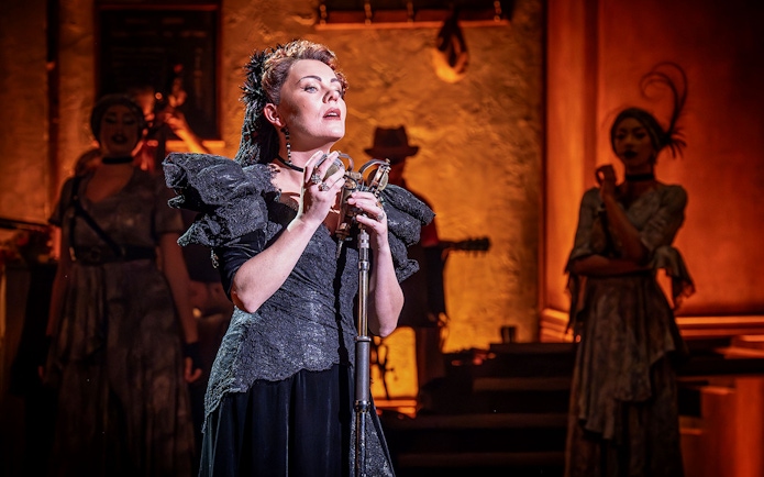 Performer singing on stage during Hadestown musical.