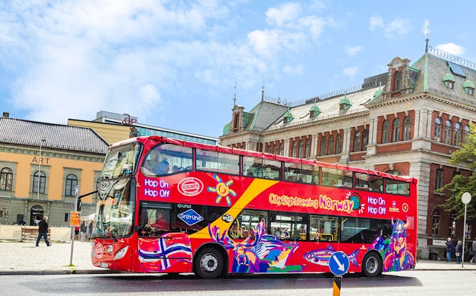 Bergen city sightseeing bus in front of historic buildings.