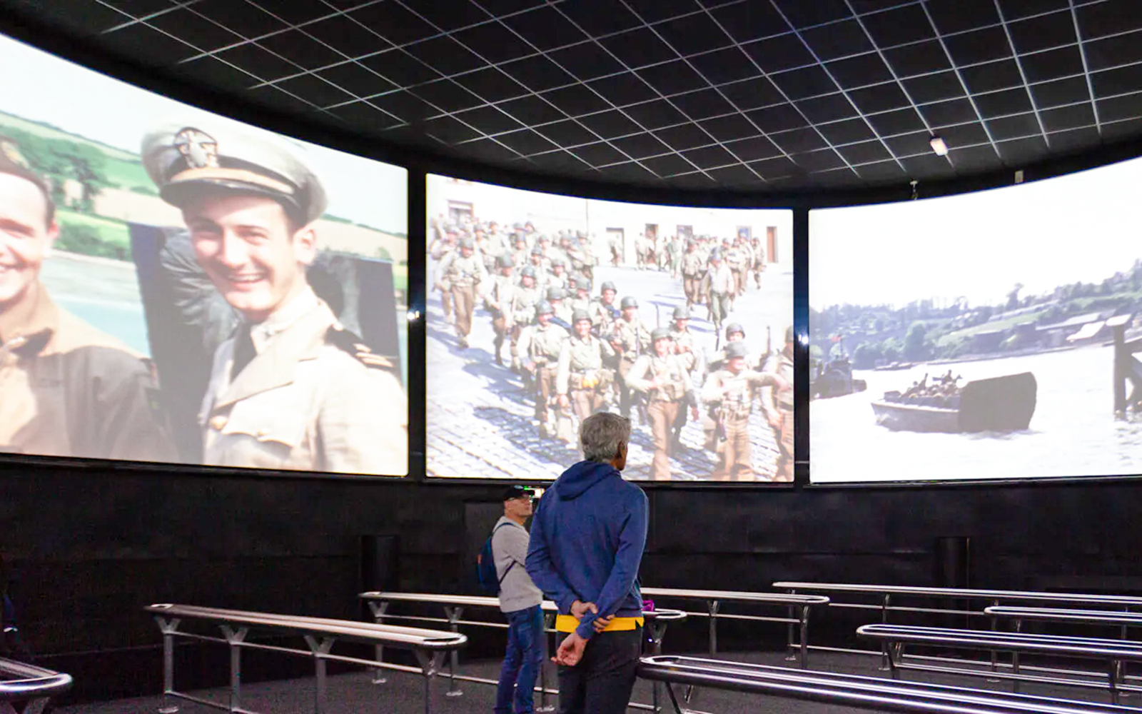 Visitors watching historical footage at Arromanches 360 Circular Cinema, France.