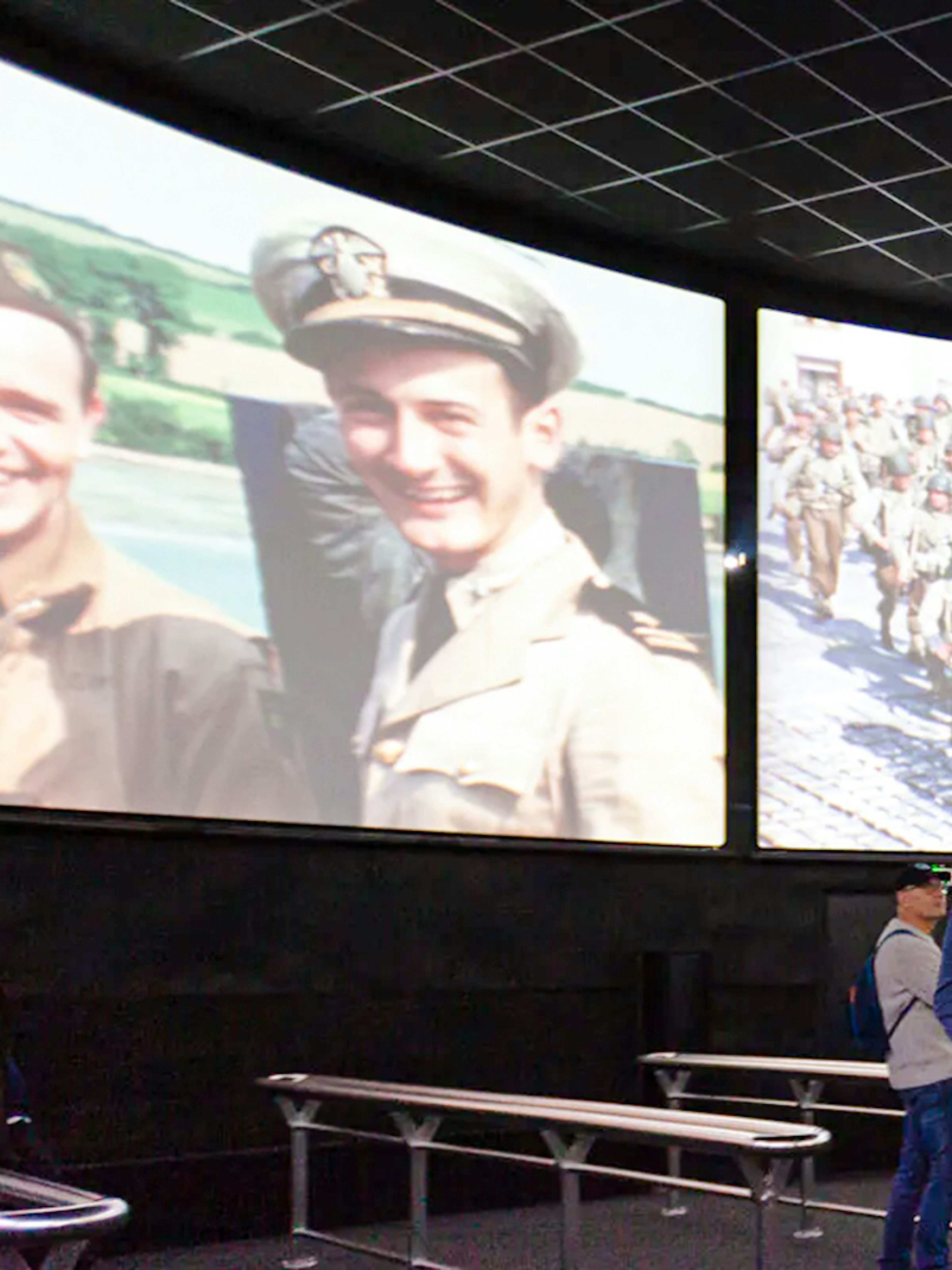 Visitors watching historical footage at Arromanches 360 Circular Cinema, France.