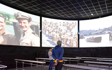 Visitors watching historical footage at Arromanches 360 Circular Cinema, France.