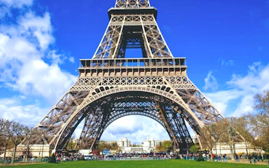 Eiffel Tower base with tourists, Paris, view from Champ de Mars.