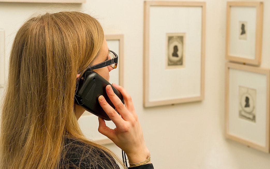 Visitor using an audio guide at Mozarthaus Vienna exhibition.