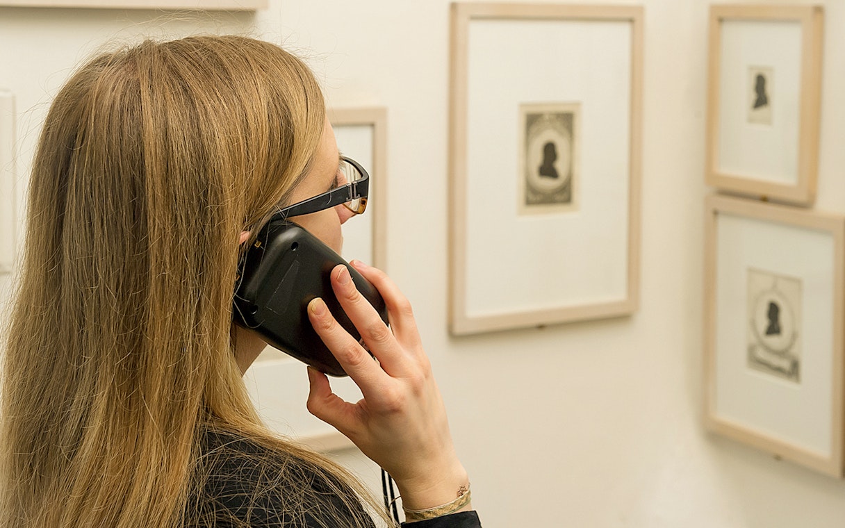 Visitor using an audio guide at Mozarthaus Vienna exhibition.