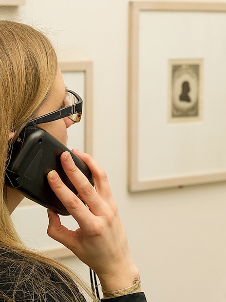 Visitor using an audio guide at Mozarthaus Vienna exhibition.