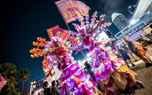 Performers in colorful costumes at Singapore Formula 1 event.