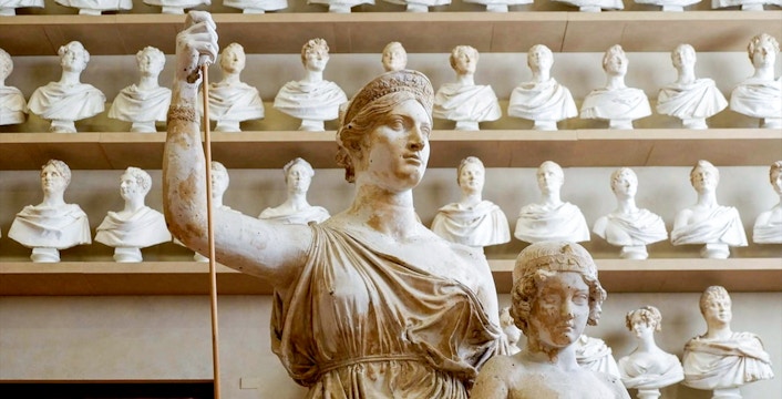 Statues in Florence's Accademia Gallery, featuring classical sculptures and busts.