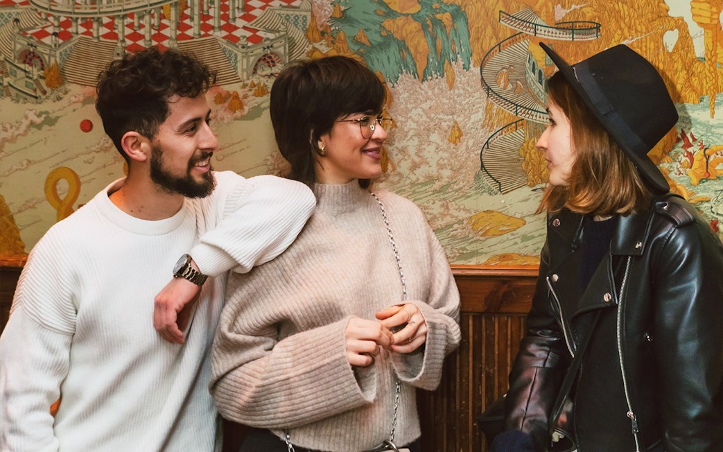 Group of people enjoying a conversation in front of a colorful mural during a Barcelona walking tour.