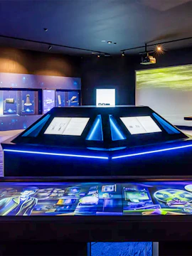 Interactive exhibit at a science museum with illuminated displays and digital screens.