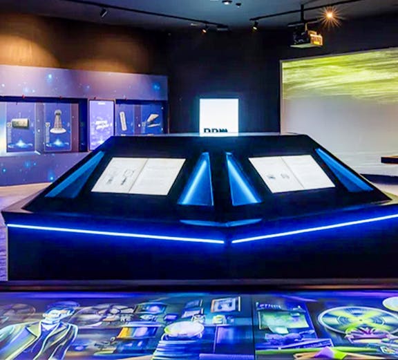 Interactive exhibit at a science museum with illuminated displays and digital screens.