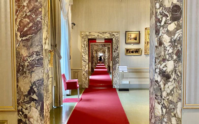 Marble hallway with red carpet at Gallery of Modern Art, Pitti Palace, Florence.