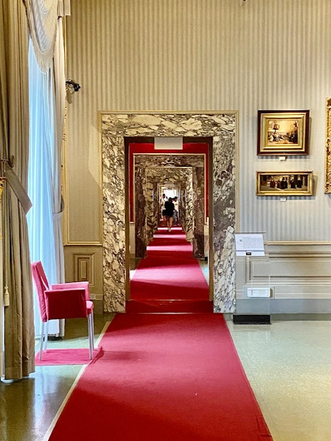 Marble hallway with red carpet at Gallery of Modern Art, Pitti Palace, Florence.