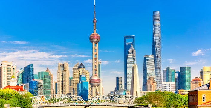 Oriental Pearl Tower and Shanghai skyline with Huangpu River in foreground.