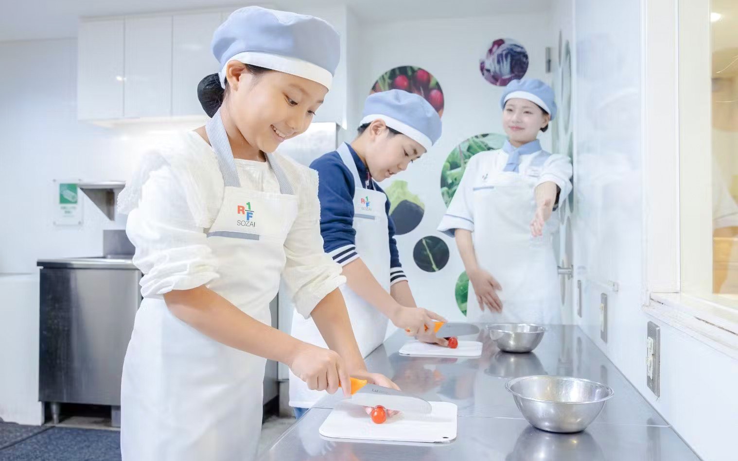 Children learning to cook with a chef at KidZania Osaka Koshien.