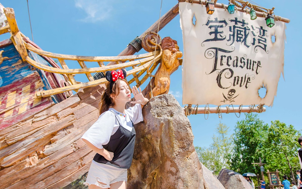 Treasure Cove sign and visitor at Shanghai Disneyland.