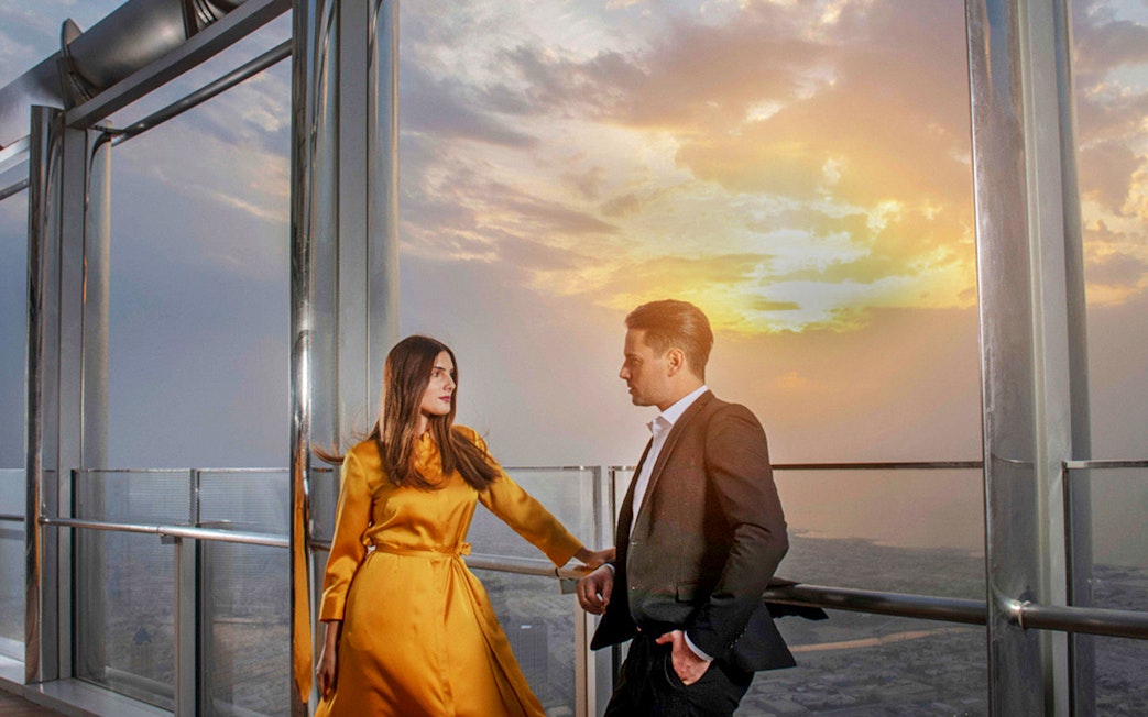 Couple enjoying sunset view from Burj Khalifa's At the Top Sky Lounge, Level 152.